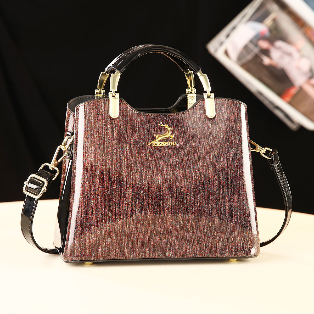 Brown handbag with gold accents on a white surface