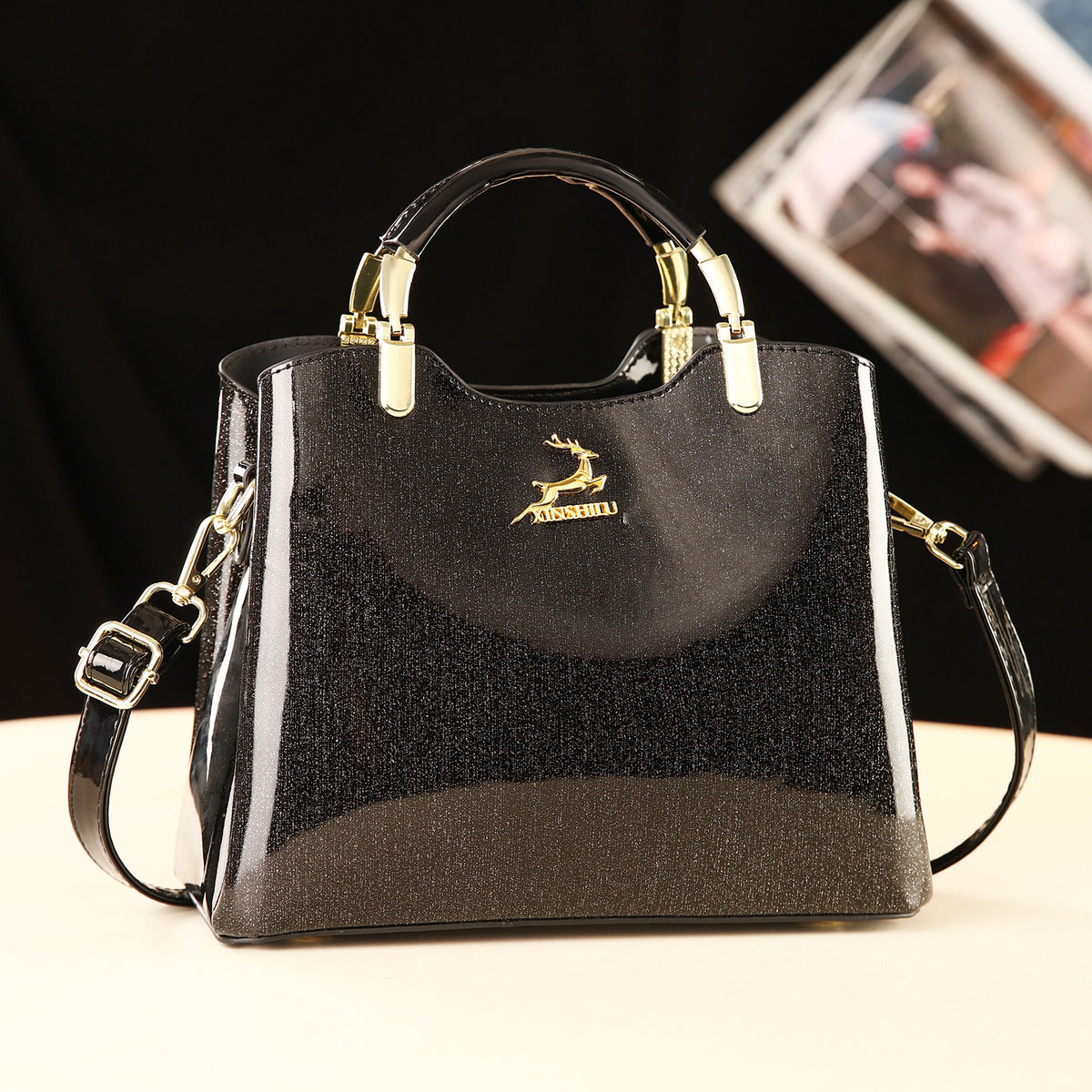 Black handbag with gold accents on a white surface