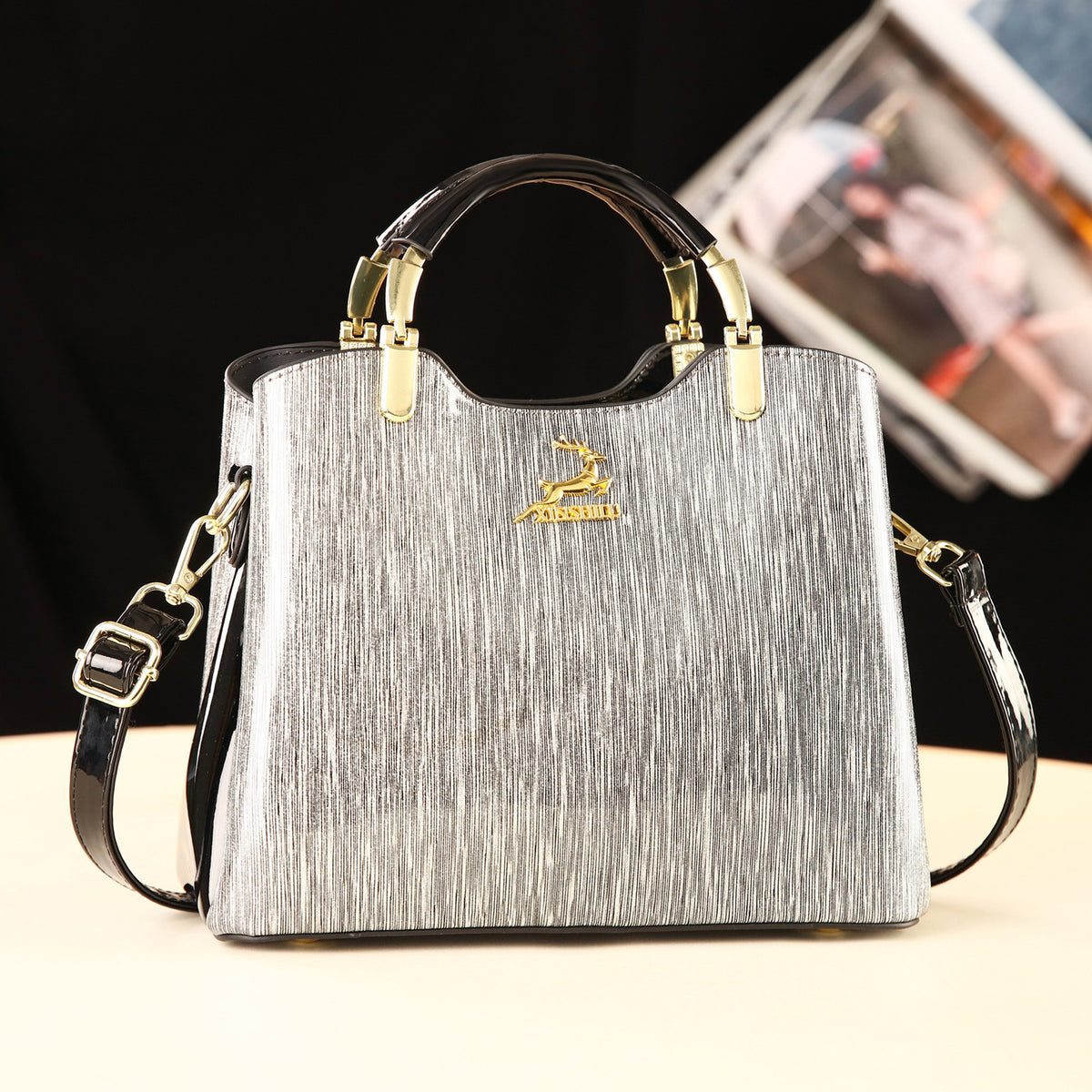 Silver handbag with gold accents on a white background
